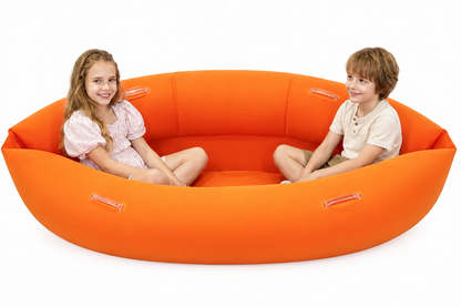 Children seated facing each other in the orange peapod