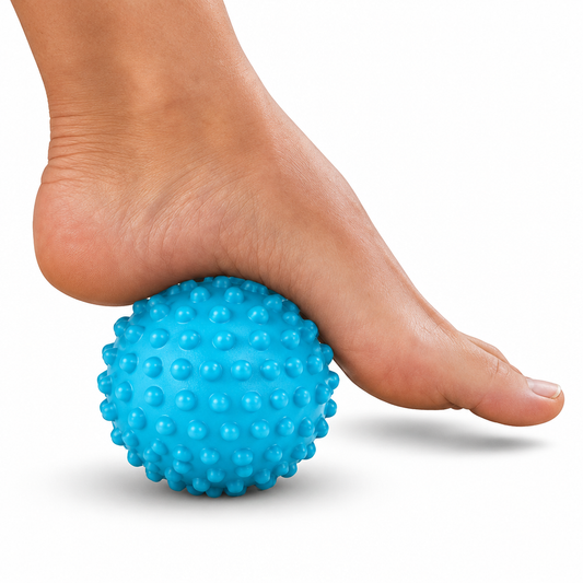 Foot resting on a blue massage ball on white